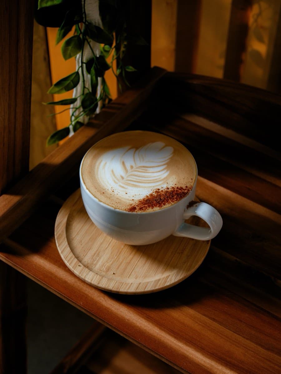 Cappuccino con latte art en bandeja de madera